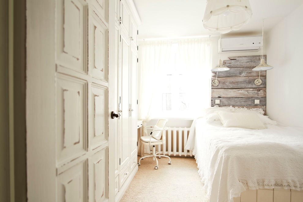 На фото: хозяйская спальня в стиле шебби-шик с белыми стенами и ковровым покрытием с