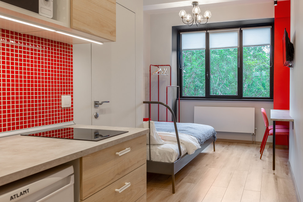 На фото: маленькая спальня в стиле модернизм с красными стенами и полом из ламината для на участке и в саду