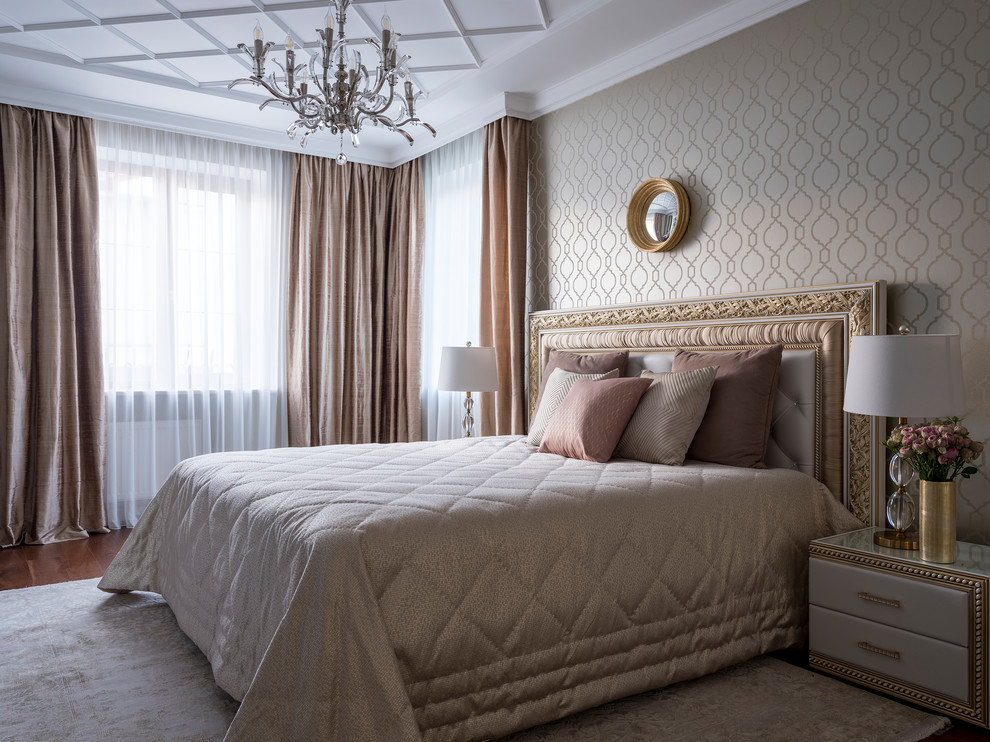 Modelo de dormitorio principal clásico con paredes beige, suelo de madera en tonos medios y suelo marrón