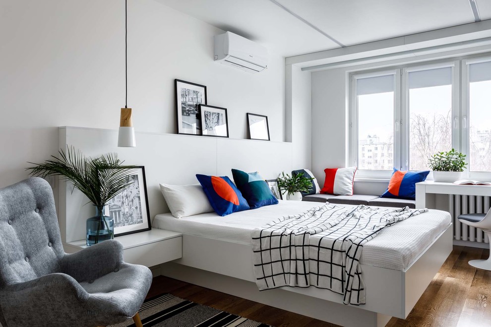 Foto de dormitorio principal escandinavo pequeño con paredes blancas y suelo de madera en tonos medios