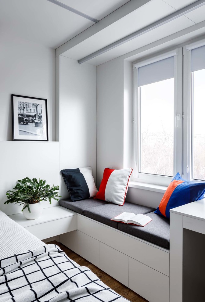 Idée de décoration pour une petite chambre parentale nordique avec un mur blanc et un sol en bois brun.