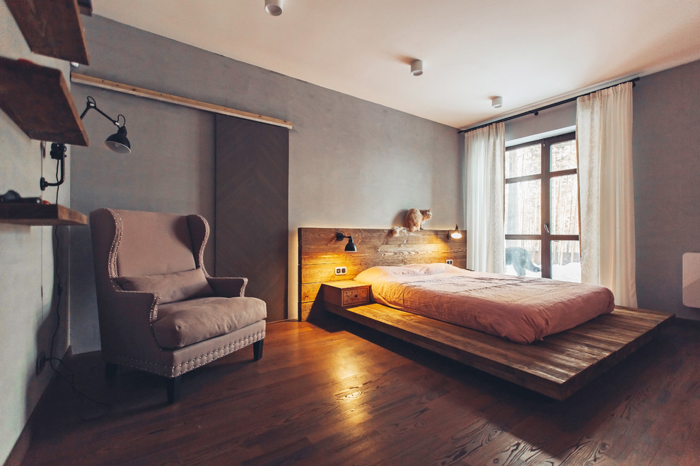 Идея дизайна: хозяйская спальня среднего размера в стиле лофт с серыми стенами, темным паркетным полом и коричневым полом без камина