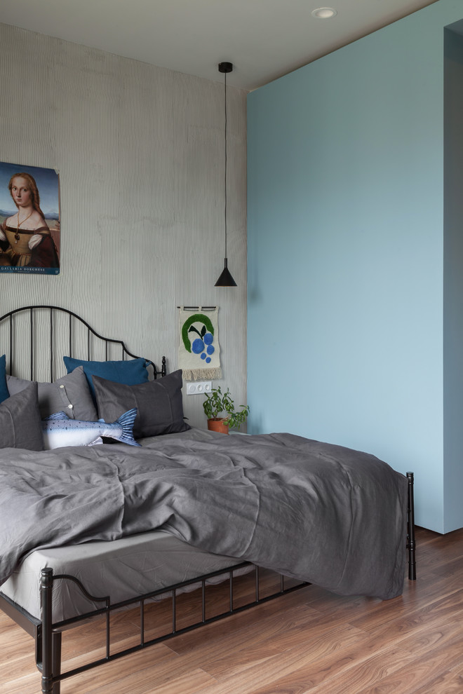 Ispirazione per una camera matrimoniale minimal con pareti blu, pavimento in legno massello medio e pavimento marrone