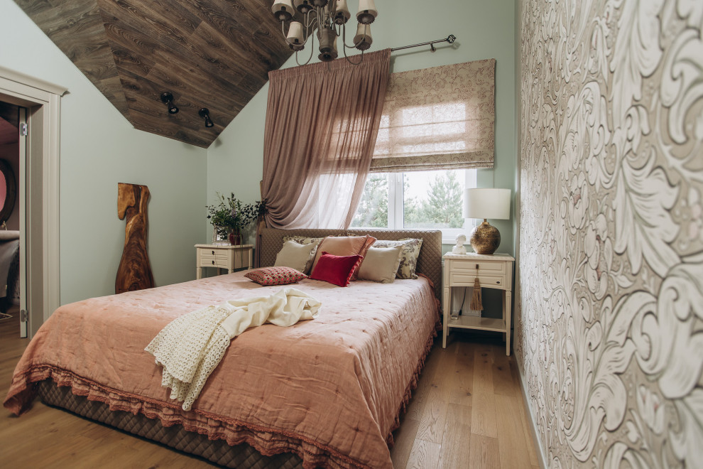 Foto de dormitorio bohemio con paredes verdes, suelo de madera clara, suelo beige y papel pintado