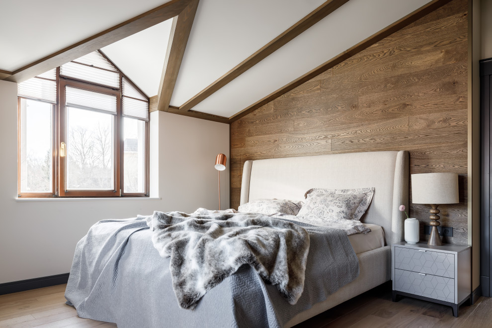 Aménagement d'une grande chambre parentale montagne avec un mur beige, un sol en bois brun, un sol beige et poutres apparentes.