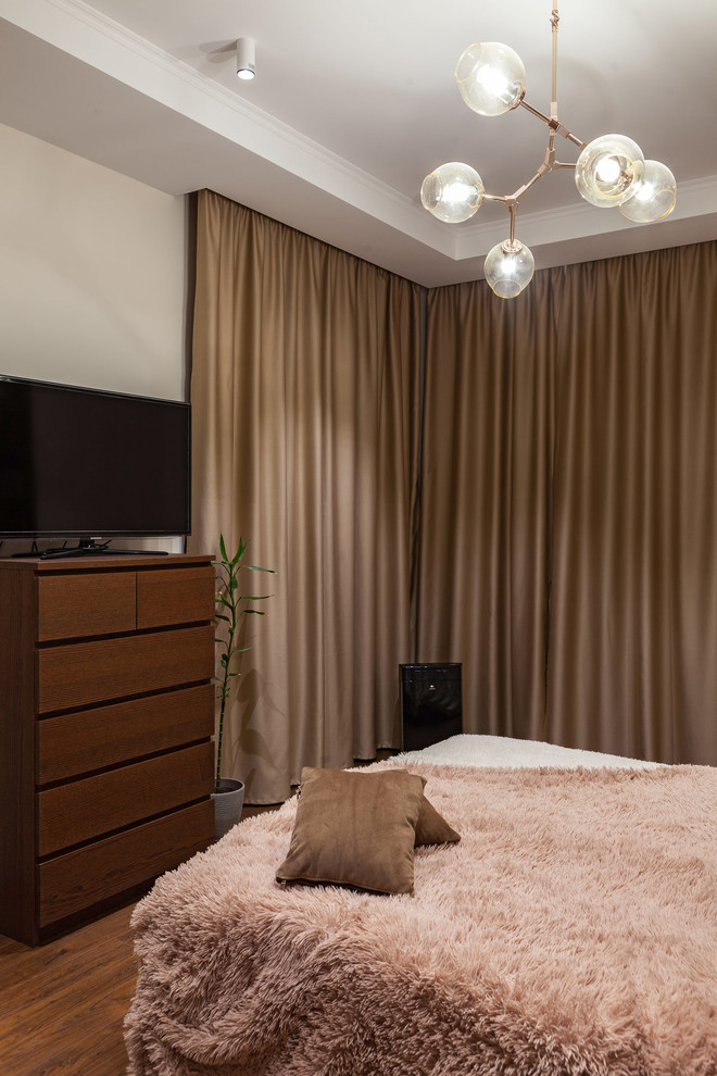 Idée de décoration pour une chambre design de taille moyenne avec un mur beige, parquet foncé et un sol marron.