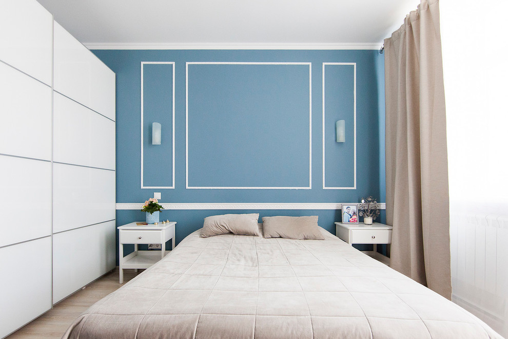Cette photo montre une chambre parentale tendance avec un mur bleu et parquet clair.