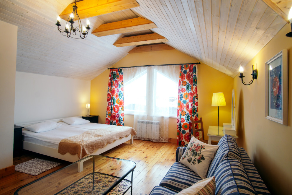 Esempio di una camera degli ospiti industriale con pareti gialle, pavimento in legno verniciato e nessun camino