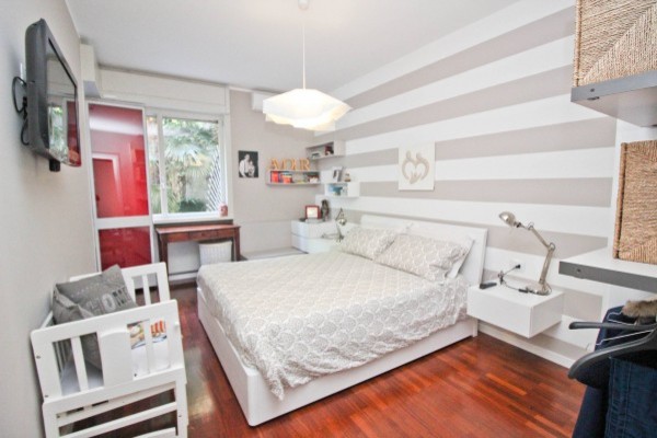 Стильный дизайн: спальня среднего размера в современном стиле с разноцветными стенами, полом из ламината и коричневым полом - последний тренд