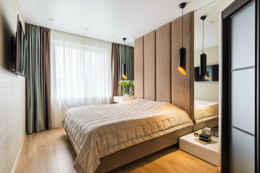 Imagen de dormitorio principal contemporáneo con suelo de madera clara y suelo beige