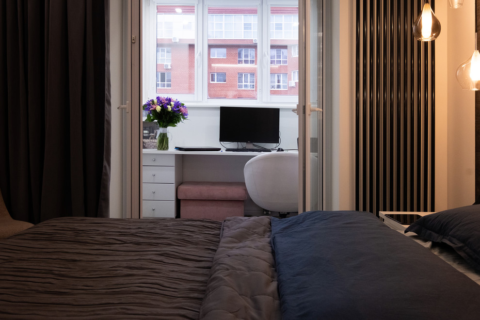Imagen de dormitorio principal actual de tamaño medio sin chimenea con paredes blancas, suelo laminado y suelo gris