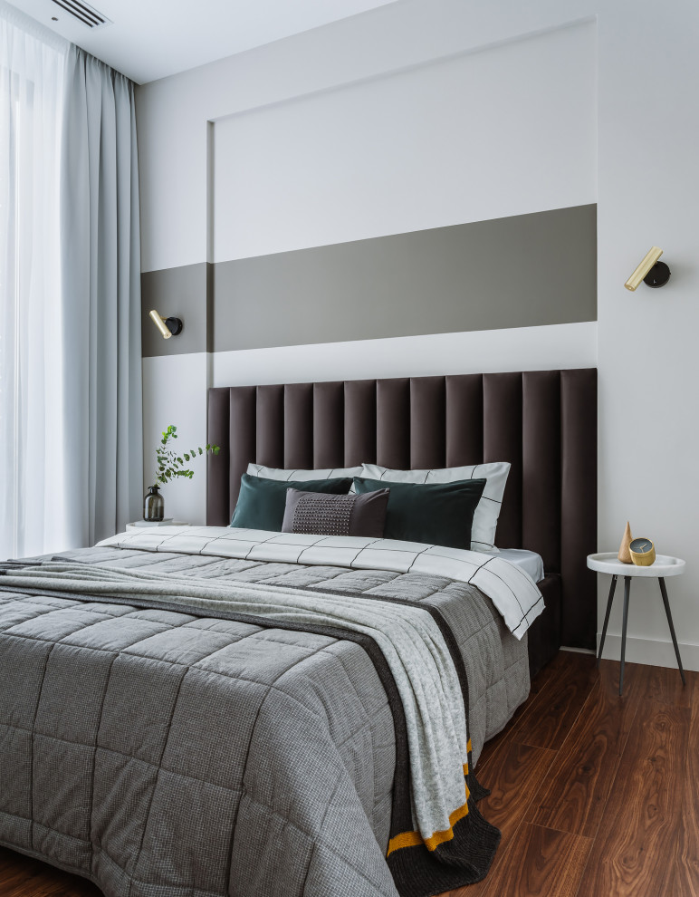 Свежая идея для дизайна: хозяйская, серо-белая спальня среднего размера в современном стиле с серыми стенами, полом из ламината и коричневым полом - отличное фото интерьера