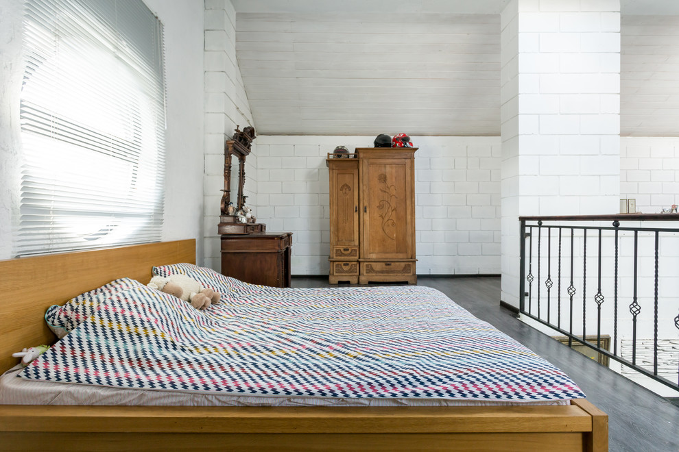 Imagen de dormitorio tipo loft ecléctico grande con paredes blancas y suelo de madera oscura
