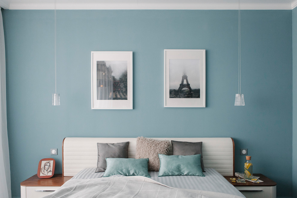 Cette photo montre une chambre parentale tendance avec un mur bleu.