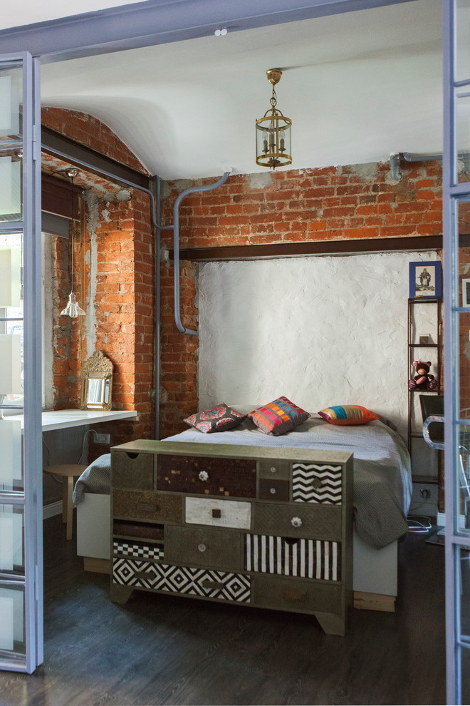 На фото: хозяйская спальня в стиле лофт с коричневыми стенами, темным паркетным полом и кроватью в нише