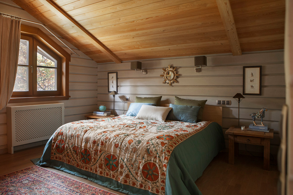 На фото: хозяйская спальня в стиле кантри с белыми стенами и паркетным полом среднего тона с