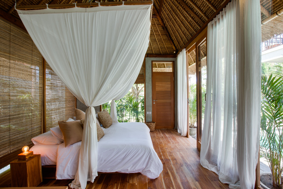 Idee per una camera da letto tropicale con pavimento in legno massello medio e pavimento marrone