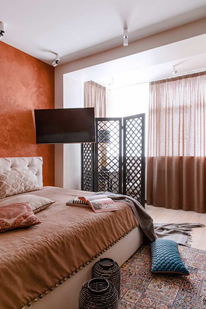 Design ideas for a world-inspired bedroom in Other with orange walls, light hardwood flooring and beige floors.