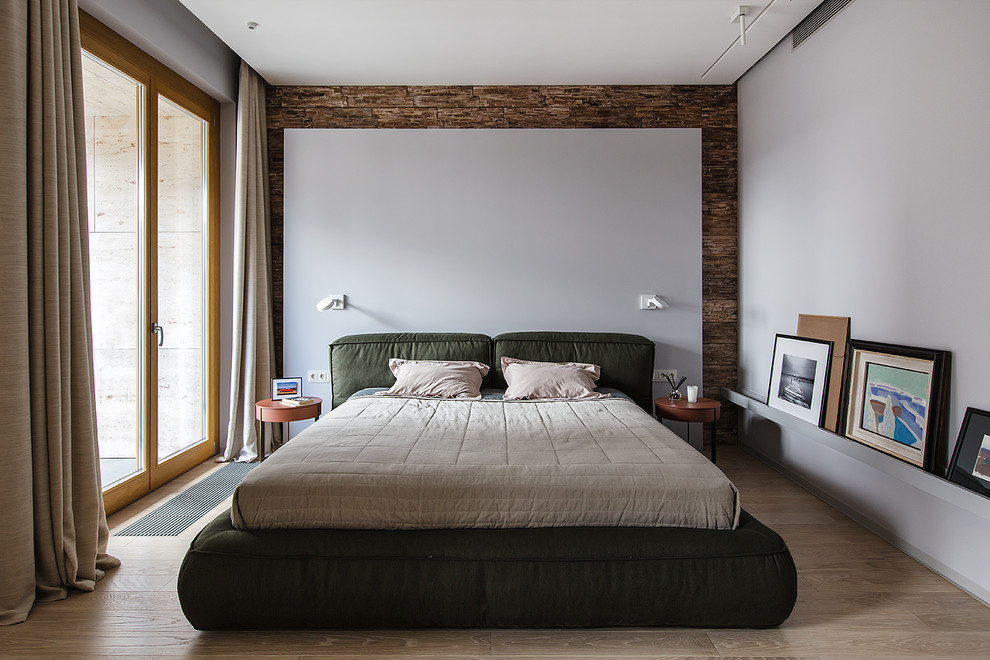 Modernes Hauptschlafzimmer mit weißer Wandfarbe, hellem Holzboden und beigem Boden in Moskau