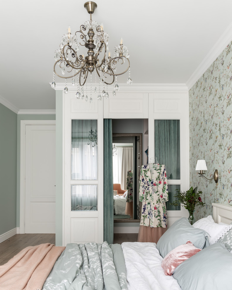 Diseño de dormitorio principal clásico pequeño sin chimenea con paredes verdes, suelo laminado, suelo beige y papel pintado