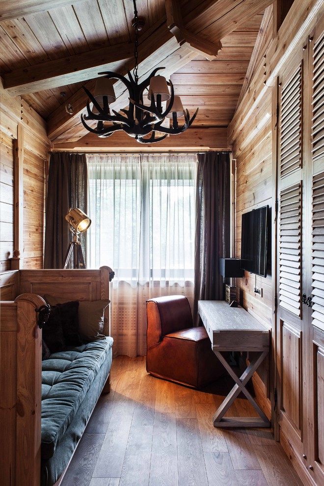 Foto di una camera degli ospiti rustica con pareti marroni e pavimento in legno massello medio