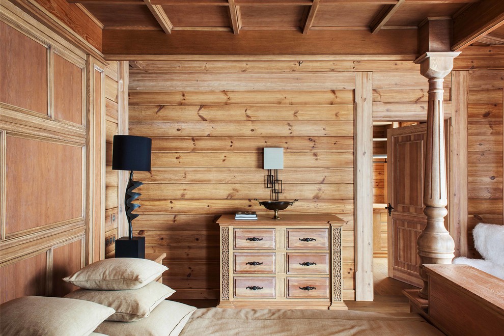 Modelo de dormitorio principal rústico con paredes marrones y suelo de madera en tonos medios
