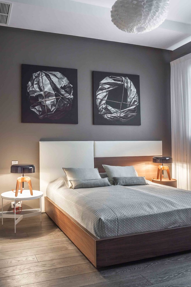 На фото: гостевая спальня среднего размера, (комната для гостей) в современном стиле с серыми стенами и паркетным полом среднего тона