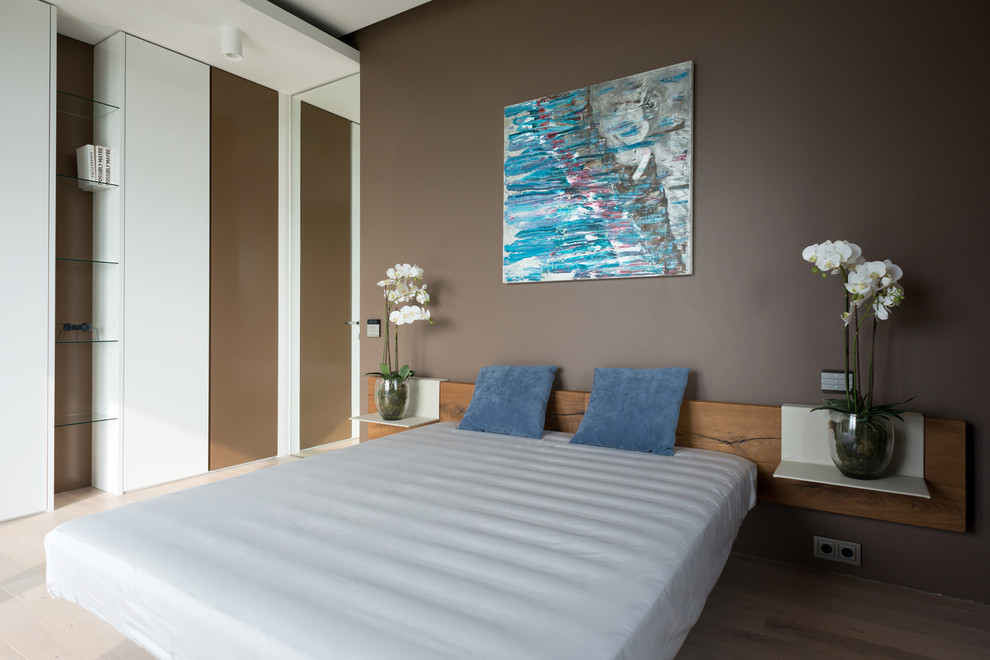 Imagen de dormitorio contemporáneo de tamaño medio con paredes marrones y suelo de madera en tonos medios