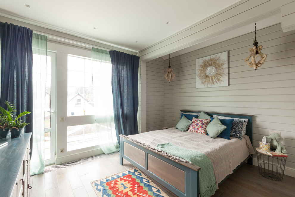 Foto di una camera degli ospiti minimal di medie dimensioni con pareti grigie, pavimento in legno massello medio e pavimento grigio