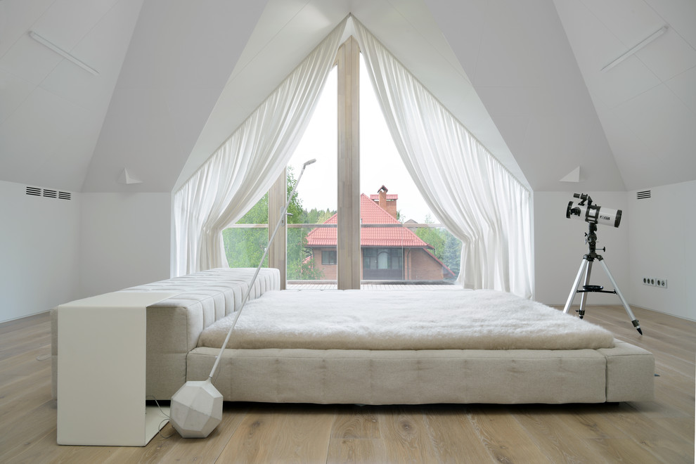 Diseño de dormitorio principal actual grande con paredes blancas, suelo de madera en tonos medios y suelo beige