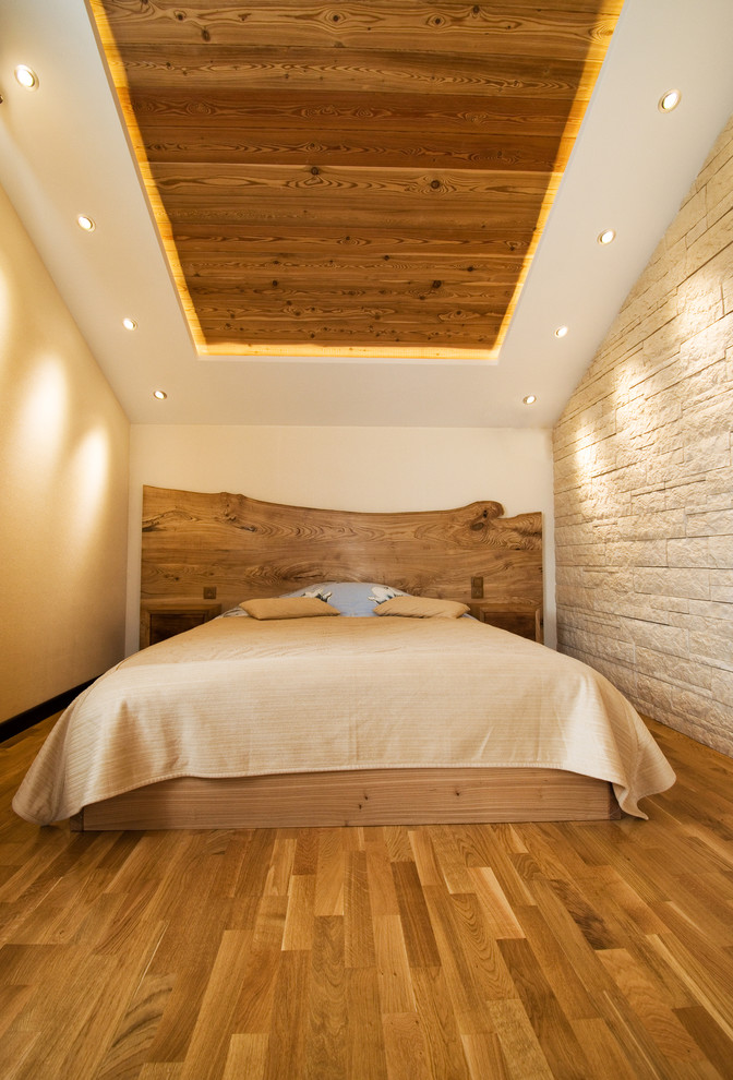 Ejemplo de dormitorio principal campestre de tamaño medio con paredes beige, suelo de madera en tonos medios y suelo marrón