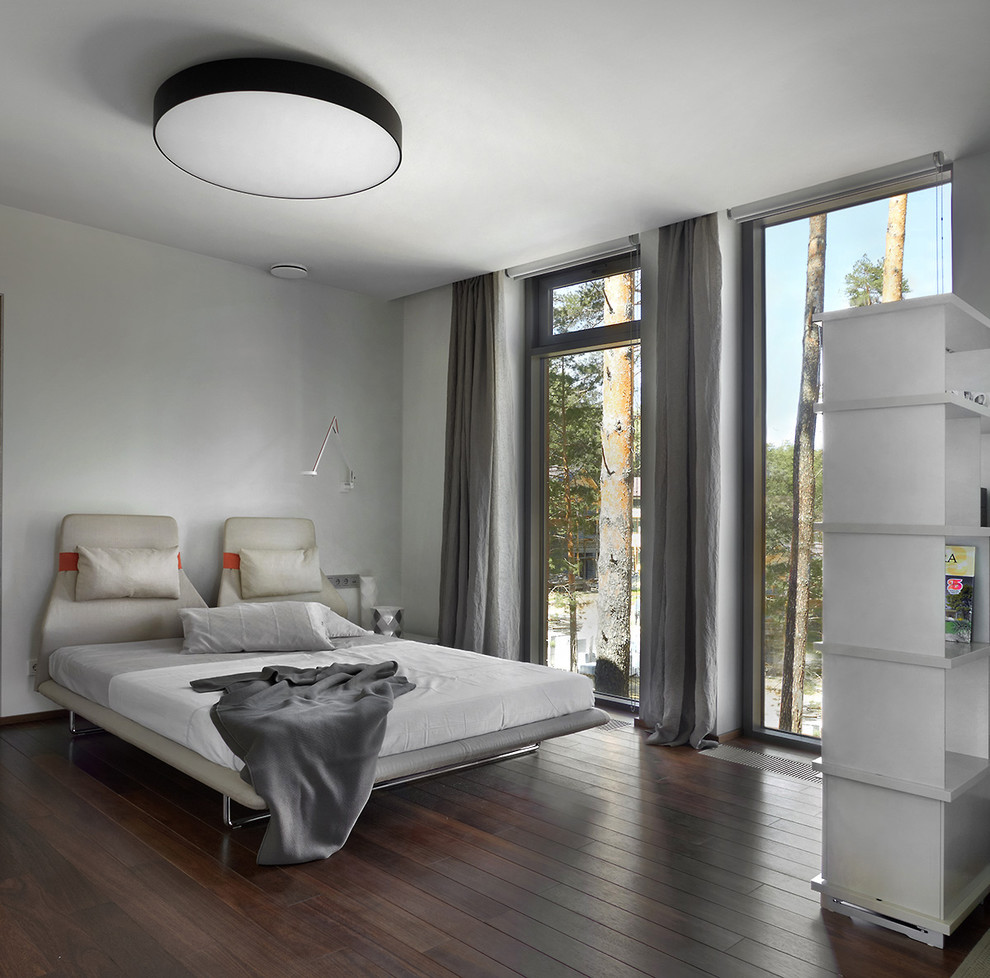 Источник вдохновения для домашнего уюта: спальня в современном стиле с серыми стенами, темным паркетным полом и кроватью в нише