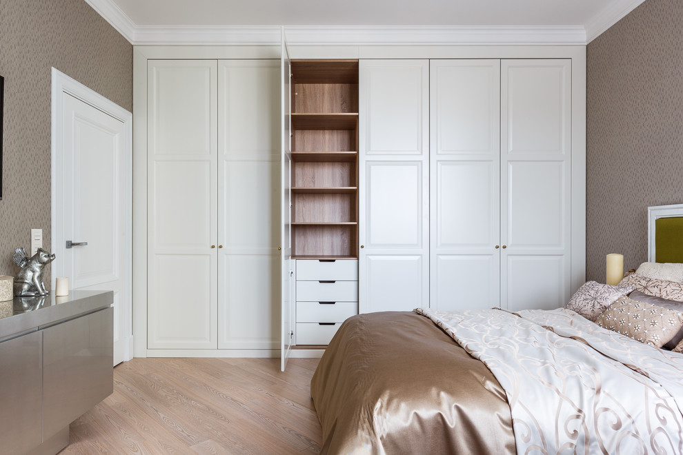 Klassisches Schlafzimmer mit beiger Wandfarbe, hellem Holzboden und beigem Boden in Sonstige