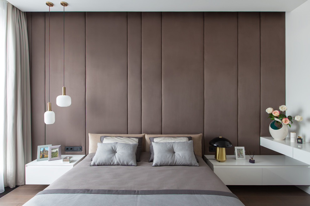 На фото: большая хозяйская спальня в современном стиле с белыми стенами, паркетным полом среднего тона, коричневым полом и акцентной стеной с