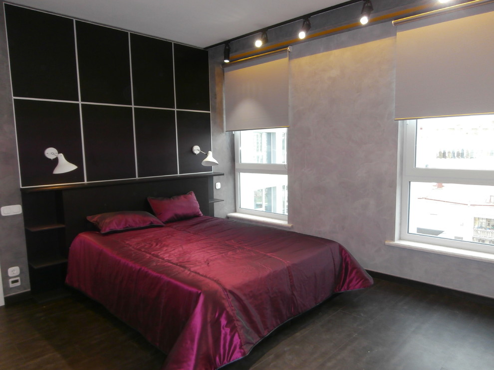 Modelo de dormitorio principal actual de tamaño medio con paredes grises, suelo de baldosas de porcelana y suelo negro
