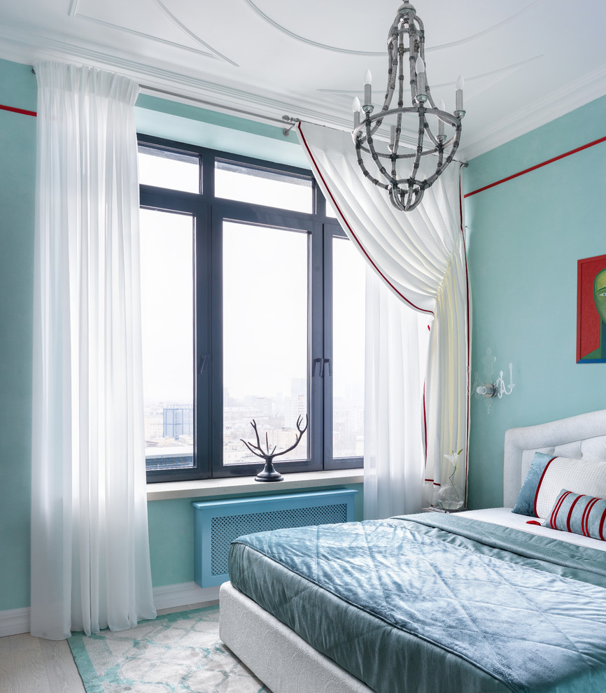 Modelo de dormitorio principal actual con suelo de madera clara, suelo beige y paredes azules