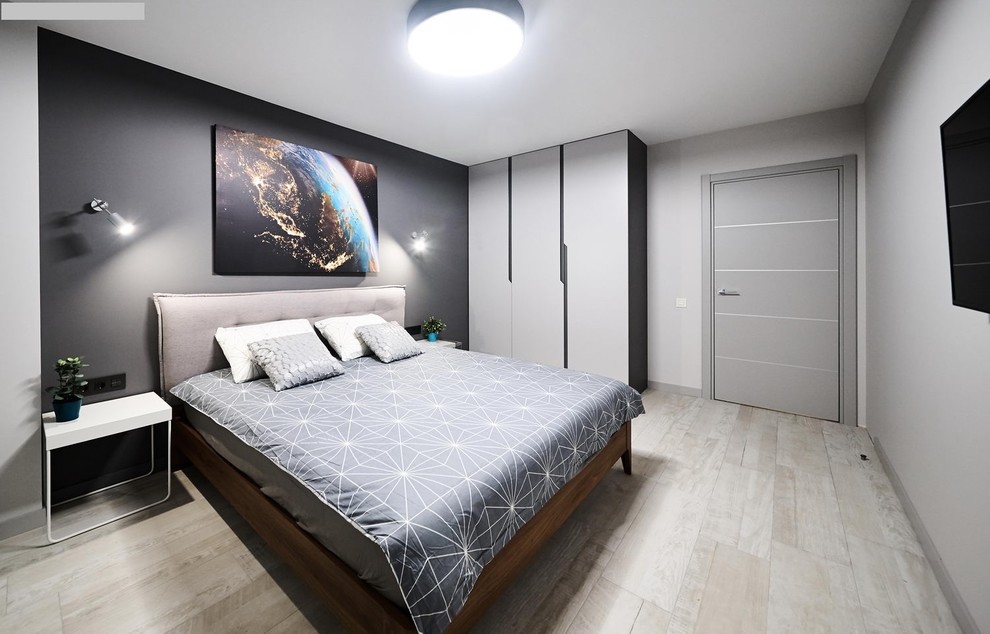 Diseño de dormitorio principal urbano pequeño con paredes grises, suelo laminado y suelo gris