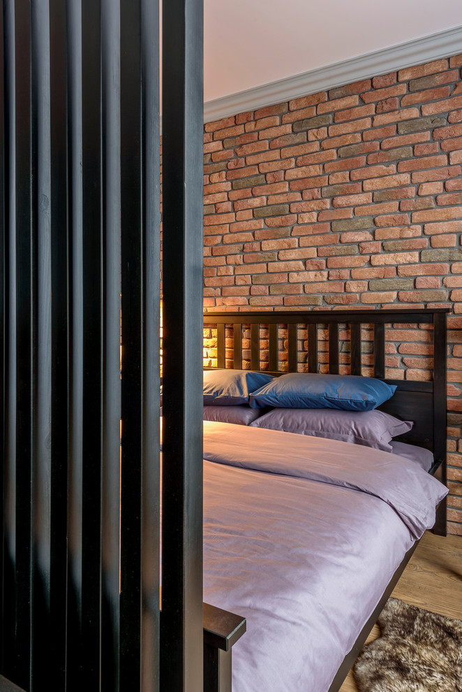 Immagine di una piccola camera da letto stile loft industriale con pareti rosse e pavimento in legno massello medio