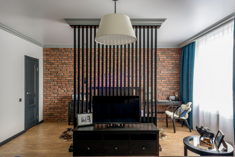 Imagen de dormitorio tipo loft urbano pequeño con paredes grises y suelo de madera en tonos medios