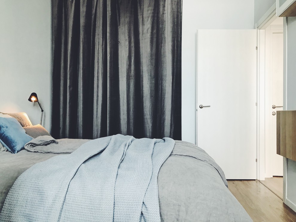 Foto de dormitorio principal escandinavo de tamaño medio con paredes blancas, suelo laminado y suelo beige