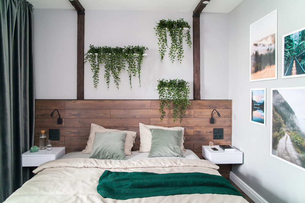Свежая идея для дизайна: хозяйская спальня среднего размера в современном стиле с серыми стенами, полом из ламината и коричневым полом без камина - отличное фото интерьера