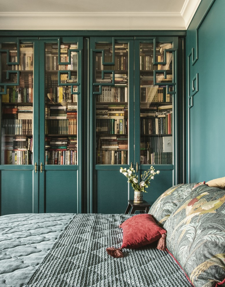 Modelo de dormitorio principal bohemio de tamaño medio con paredes verdes, suelo de madera pintada, todas las chimeneas, marco de chimenea de madera y suelo negro