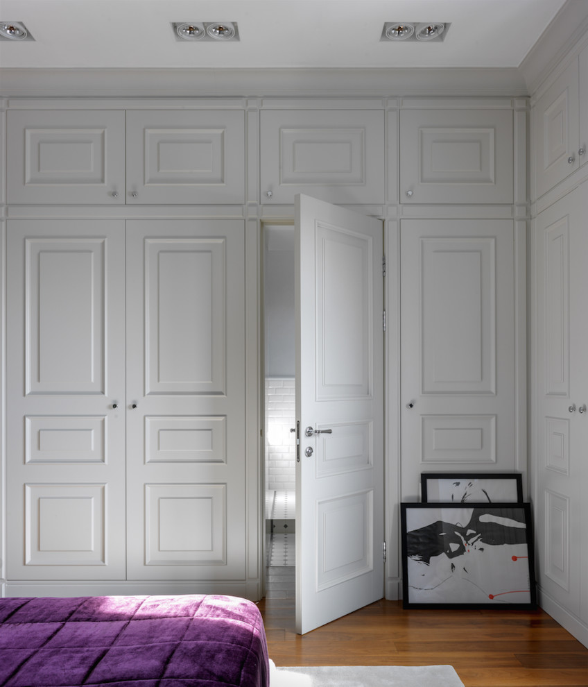 Klassisches Hauptschlafzimmer mit braunem Holzboden, braunem Boden und weißer Wandfarbe in Moskau