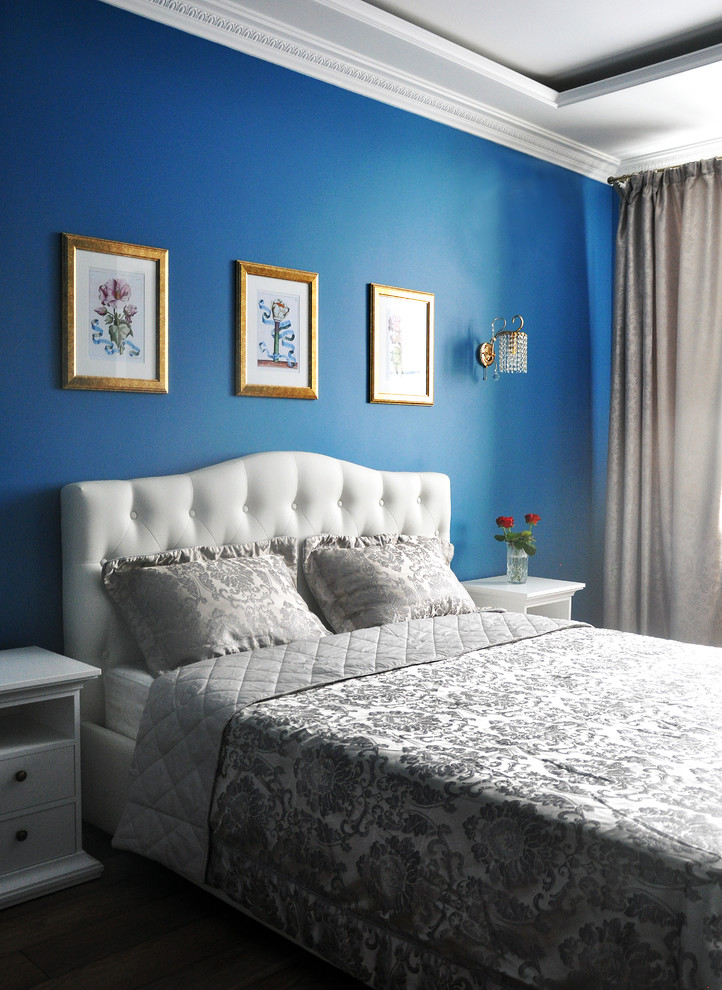 Esempio di una piccola camera matrimoniale minimal con pareti blu, pavimento in laminato, nessun camino e pavimento marrone