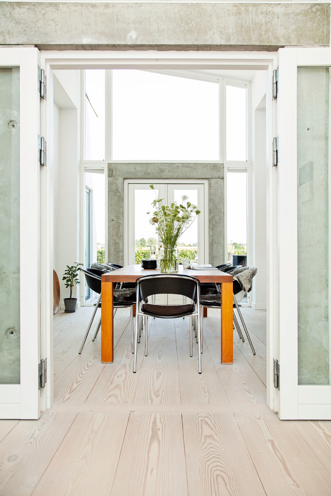 Cette photo montre une salle à manger scandinave fermée et de taille moyenne avec sol en stratifié et un sol beige.