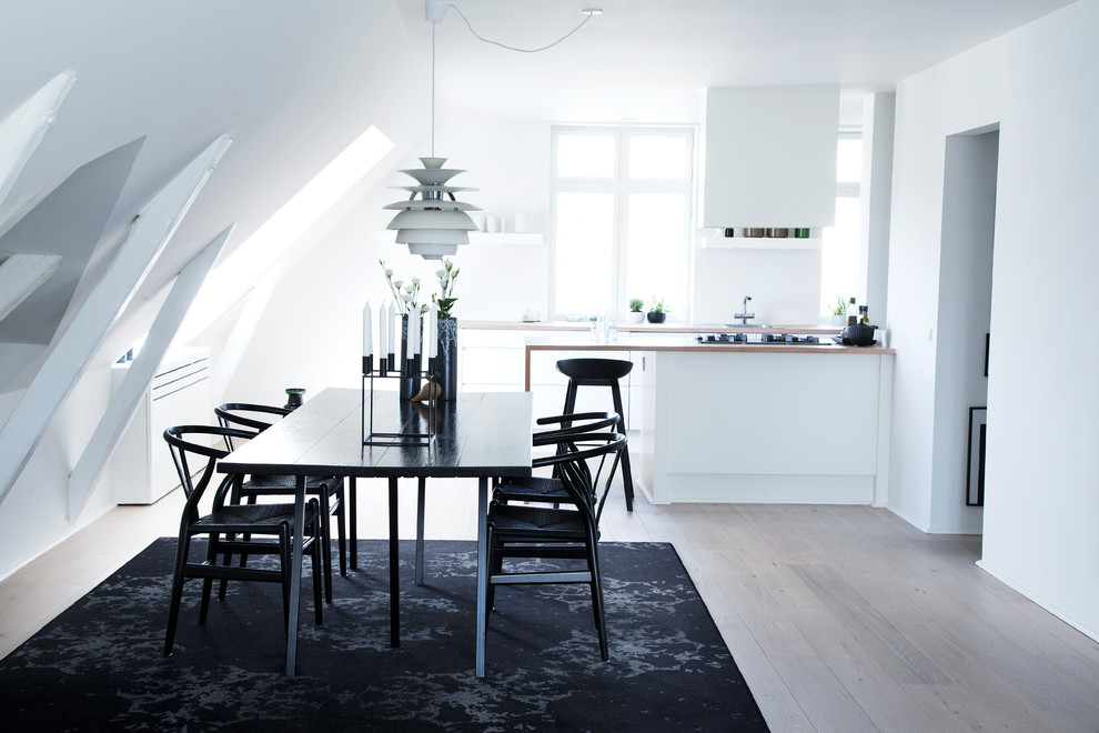 Inspiration pour une salle à manger ouverte sur la cuisine nordique de taille moyenne avec un mur blanc et un sol blanc.