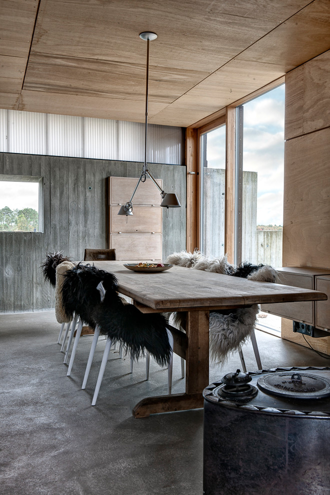 Cette photo montre une salle à manger montagne avec sol en béton ciré et un sol gris.