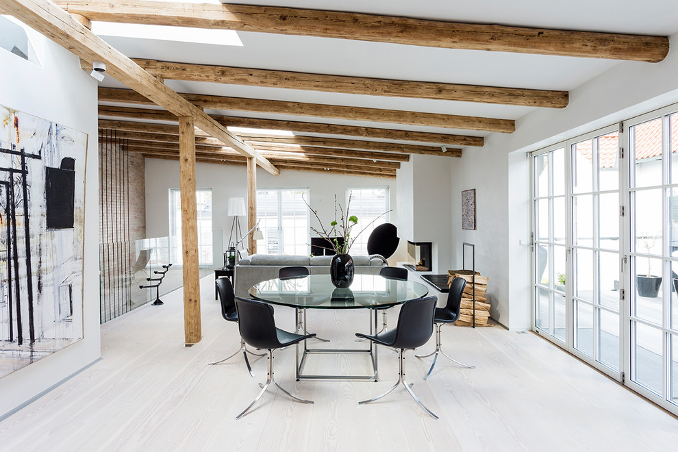 Esempio di una sala da pranzo aperta verso il soggiorno contemporanea con pareti bianche, parquet chiaro, camino bifacciale e pavimento beige
