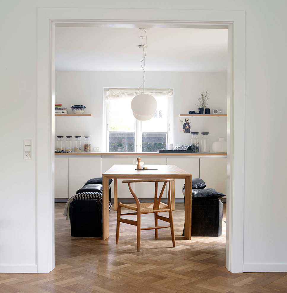 Idee per una sala da pranzo scandinava con pareti bianche e pavimento in legno massello medio