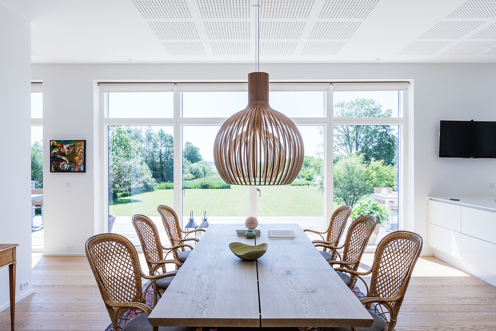 Ispirazione per una sala da pranzo minimal con pareti bianche, pavimento marrone e pavimento in legno massello medio